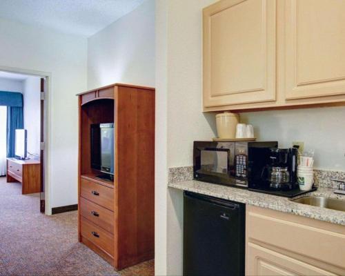 a kitchen with a sink and a counter with a microwave at Quality Inn & Suites Airport in Austin
