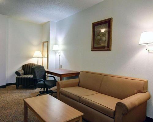 a living room with a couch and a table and chairs at Quality Inn & Suites Airport in Austin