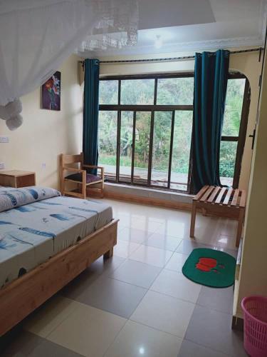 a bedroom with a bed and a large window at Kakakuona Resort in Lushoto