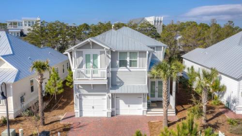 an aerial view of a white house with palm trees at Coconut Cove by AvantStay Deck w Hot Tub Access to 2 Pools in Santa Rosa Beach