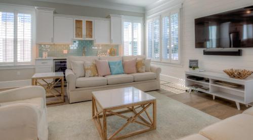 a living room with a couch and a table at Coconut Cove by AvantStay Deck w Hot Tub Access to 2 Pools in Santa Rosa Beach