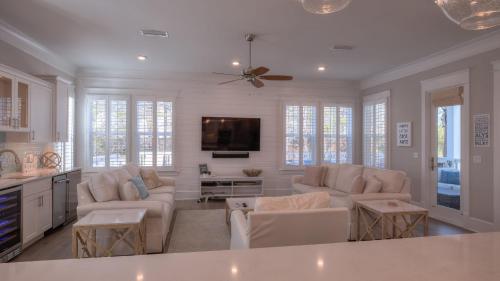a living room with two couches and a tv at Coconut Cove by AvantStay Deck w Hot Tub Access to 2 Pools in Santa Rosa Beach