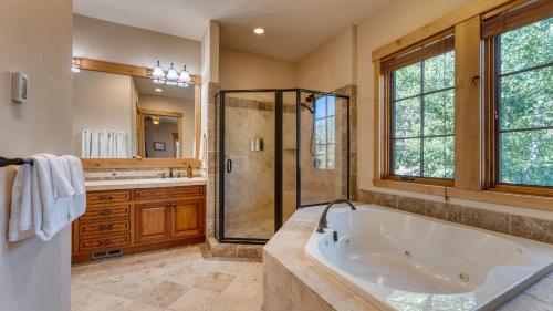Un baño grande con bañera y ducha. en Grays Crossing by AvantStay Stunning 4BDR Cabin, en Truckee