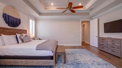 a bedroom with a bed and a ceiling fan at Coconut Cove by AvantStay Deck w Hot Tub Access to 2 Pools in Santa Rosa Beach