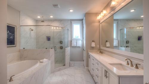a bathroom with a tub and a sink and a shower at Coconut Cove by AvantStay Deck w Hot Tub Access to 2 Pools in Santa Rosa Beach