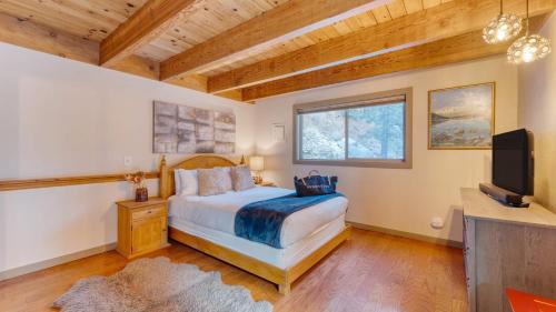 a bedroom with a bed and a television in it at Jeffrey Pines Lofted Cabin Minutes to Lake A-Frame-Inspired Design Deck in Truckee