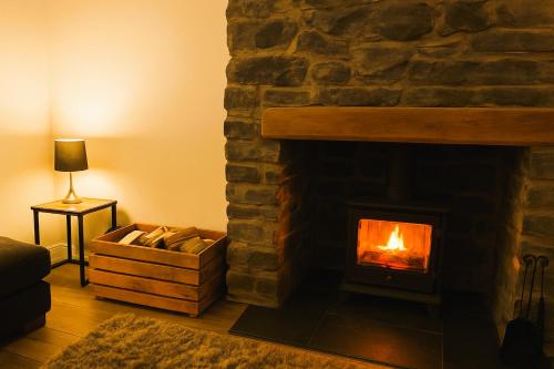 a fireplace in a living room with a fire in it at Characterful 2 bed within Conwy Walls in Conwy