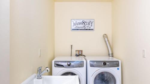 a laundry room with a washing machine and a sink at Harborview Getaway by AvantStay Walk to Beach in Langley