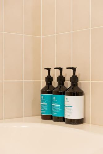 three bottles of detergent sitting on a shelf in a bathroom at Prince Smart Inn Nagoya Sakae in Nagoya