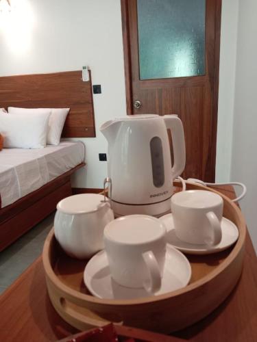 a mixer on a table with four cups and plates at Dambulla Tree House in Dambulla