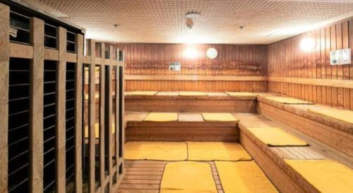 a sauna with wooden walls and benches in a room at Ou Hotel in Yonago