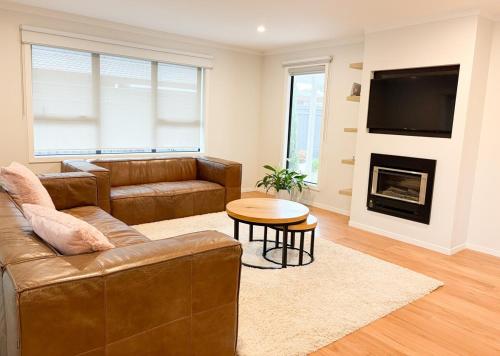 a living room with a couch and a fireplace at Modern elegance Woburn 3 bedroom Retreat in Lower Hutt