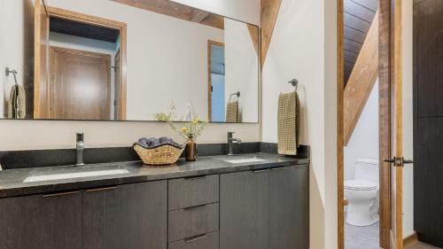a bathroom with two sinks and a mirror at Lazy River Glamp-House by AvantStay Newly Built Luxe Indoor-Outdoor Living in La Pine