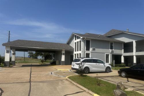 a white car parked in front of a house at Super 8 by Wyndham Bossier City/Shreveport Area in Bossier City