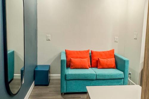 a blue couch with orange pillows in a room at Baymont by Wyndham Henrietta - Rochester in Henrietta