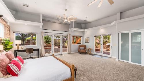 Un dormitorio con una cama y un ventilador de techo. en Mystic Sunset by AvantStay Thunder Mountain View Pool Driving Range Casita, en Sedona