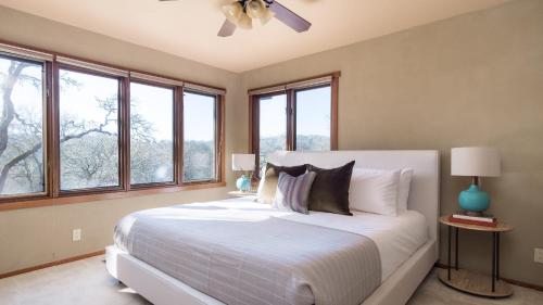 a bedroom with a large white bed with windows at Gable by AvantStay Beautiful 3.5 Acre Oasis w Gorgeous Views Pool Hot Tub in Santa Rosa
