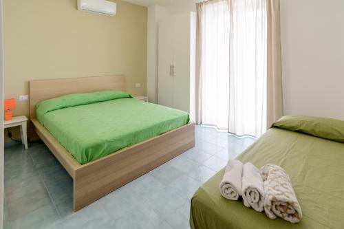 a bedroom with two beds with green sheets at Greco b&b in Agropoli