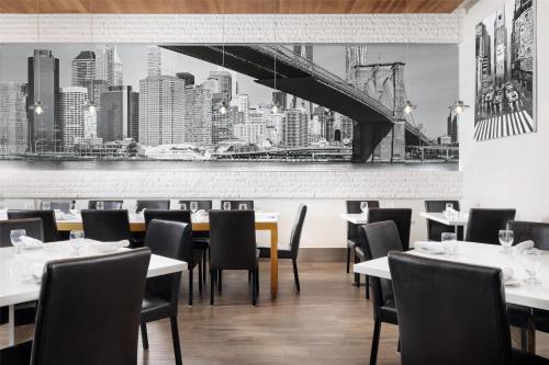a restaurant with tables and chairs and a bridge on the wall at Hilton Garden Inn New York - Times Square Central in New York