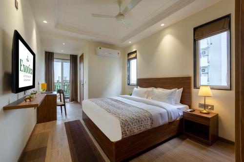 a hotel room with a bed and a television at Hotel Exotica Avenue - Business-Friendly Stay, Golf Course Road, Cyberhub, One Horizon Center & Metro in Gurgaon