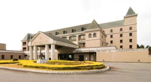 a hotel with a building with yellow flowers in front of it at HOTEL WINDSOR in Nakatsugawa