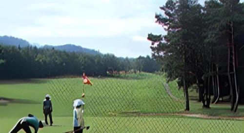 two people are playing golf on a golf course at Gujo Kogen Hotel in Shōgahora