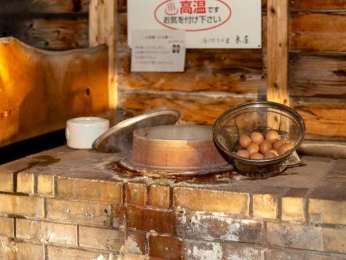 a bowl of eggs on top of a brick counter at Yukemuri no sato azumaya in Beppu