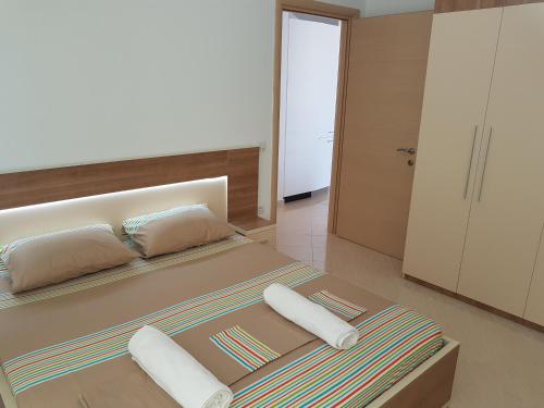 a bedroom with a large bed with two pillows at Flori beach Apartment Radhime in Radhimë