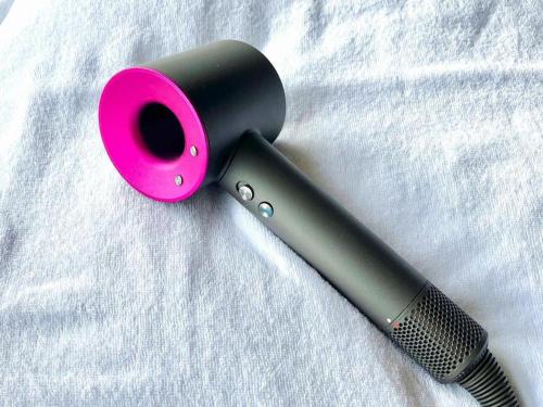 a black and pink hairbrush sitting on a white blanket at Yukemuri no sato azumaya in Beppu