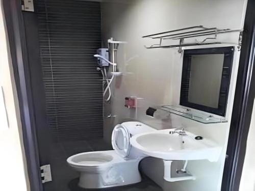 a bathroom with a white toilet and a sink at Admiral Hotel in Sitiawan