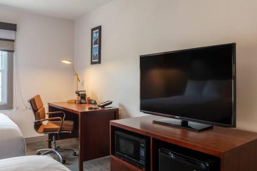 a room with a large flat screen tv on a wooden entertainment center at Comfort Inn Rockland - Boston in Rockland