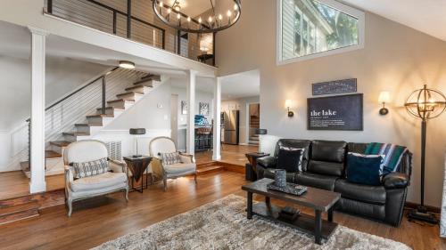 a living room with a black leather couch and chairs at Lakefront Home w Dock Game Room Hot Tub Ponderosa Peninsula by AvantStay in Mayhew