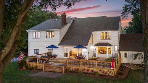 a large white house with a porch and a deck at Lakefront Home w Dock Game Room Hot Tub Ponderosa Peninsula by AvantStay in Mayhew