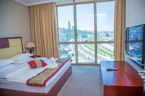 a hotel room with a bed and a large window at Golden Coast Hotel in Baku
