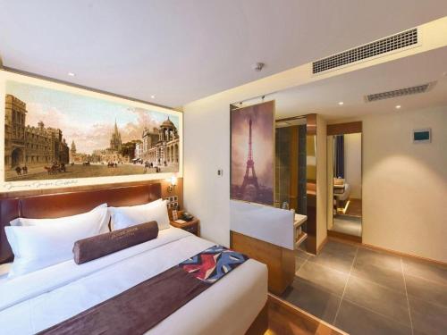 a bedroom with a large bed with a painting on the wall at James Joyce Coffetel Beijing Station in Beijing