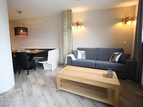 a living room with a couch and a table at Vogue Apartment in Sankt Margarethen im Lungau near Ski Lift in Sankt Margarethen im Lungau
