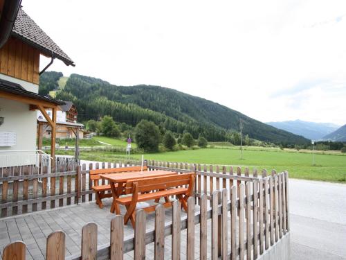 a wooden deck with a table and a fence at Vogue Apartment in Sankt Margarethen im Lungau near Ski Lift in Sankt Margarethen im Lungau