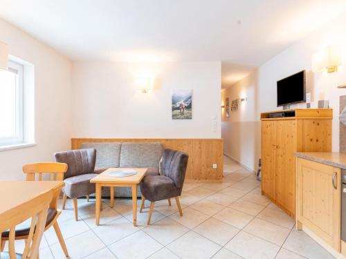 a living room with a couch and a table at Pretty Apartment in Hollersbach near forest in Hollersbach im Pinzgau