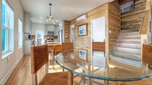 a dining room with a glass table and wooden walls at Waterfront w Bay Views Shared Pool Boat Dock Marlin Madness by AvantStay in Padre Island