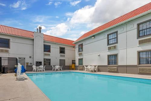 a pool with tables and chairs next to a building at Sleep Inn & Suites Merrillville in Merrillville