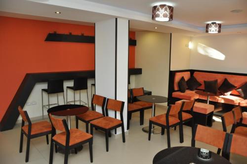 a restaurant with tables and chairs in a room at Sunrise Hotel Cameria in Durrës