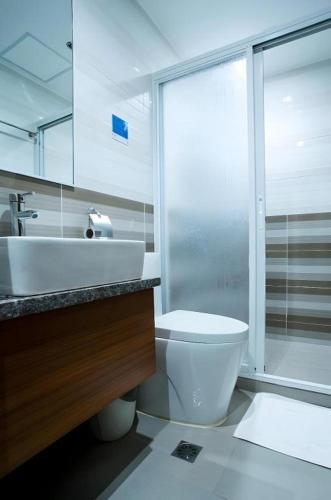 a bathroom with a toilet and a sink and a shower at Hotel Fleur de Liz in Panglao