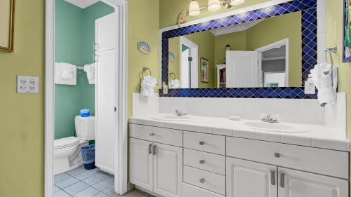 a bathroom with two sinks and a mirror at 502 Ocean Blvd by AvantStay Beachfront w Pool Ocean Views in Mount Pleasant