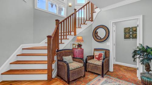 a living room with a staircase and two chairs at 502 Ocean Blvd by AvantStay Beachfront w Pool Ocean Views in Mount Pleasant
