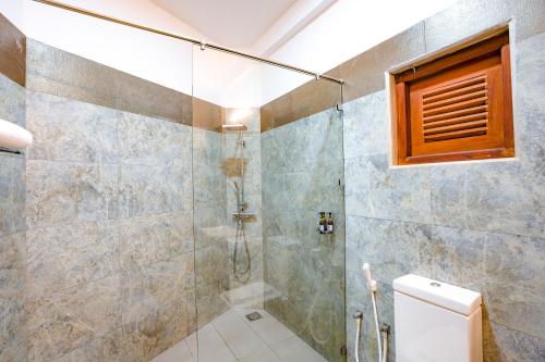 a bathroom with a shower and a toilet at Amara White Villa in Ahungalla