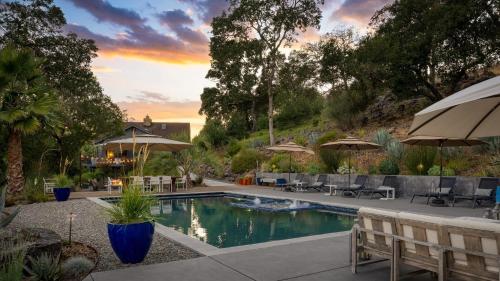 a pool with chairs and umbrellas in a yard at Kenwood Vista by AvantStay 7acres w Pool Fire Pit Vineyard Views in Kenwood