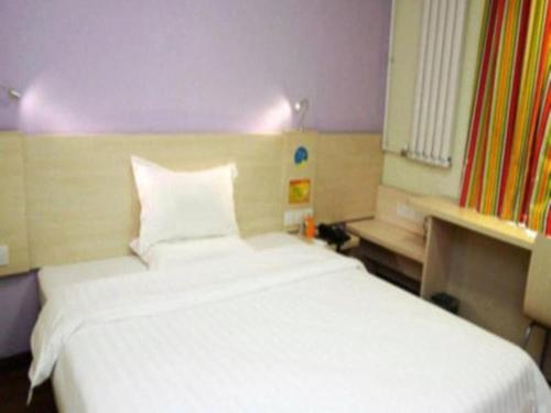 a bedroom with a large white bed in a room at 7Days Inn Xuzhou Normal University Yunlong Mountain in Xuzhou