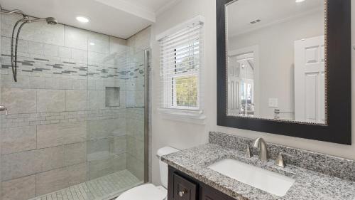 a bathroom with a shower and a sink and a toilet at Beach Retreat w Sundeck Golf Cart Bikes Bungalow House by AvantStay in Seacrest
