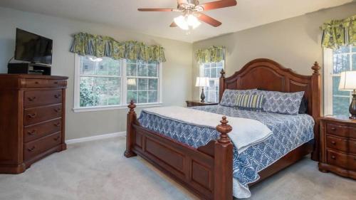 une chambre avec un lit et un ventilateur de plafond dans l'établissement Asheville Cottage Retreat by AvantStay A Charm, à Fairview