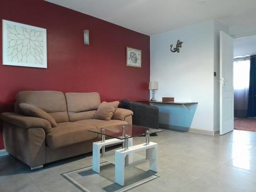 a living room with a couch and a table at Dépendance calme 47m2 confortable, 10 min aéroport in Sainte-Marie